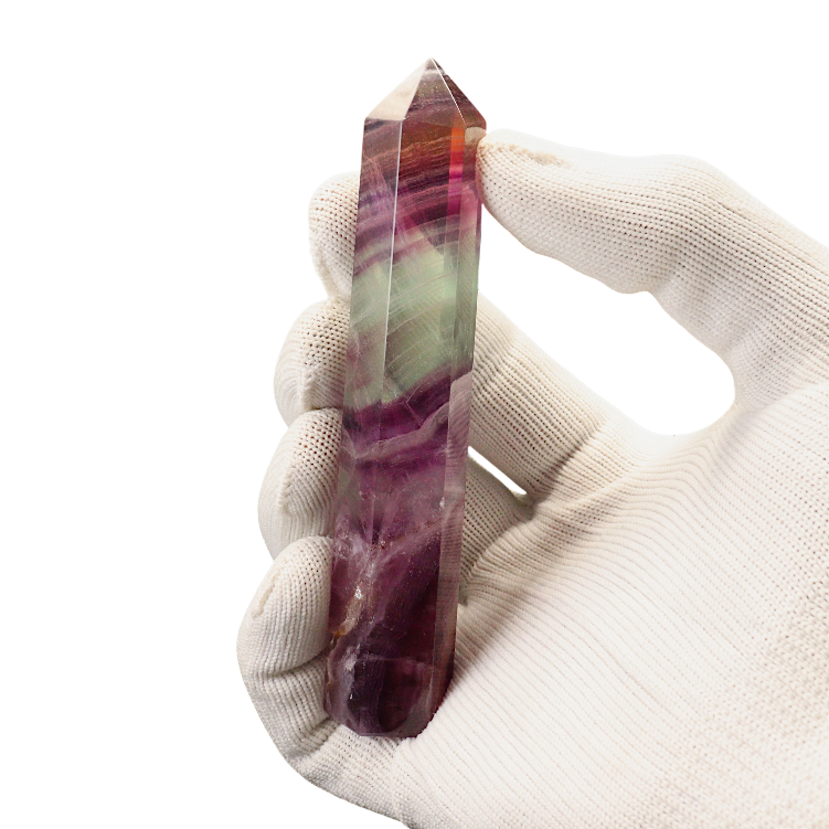 Hand holding a multicolored crystal against a white background